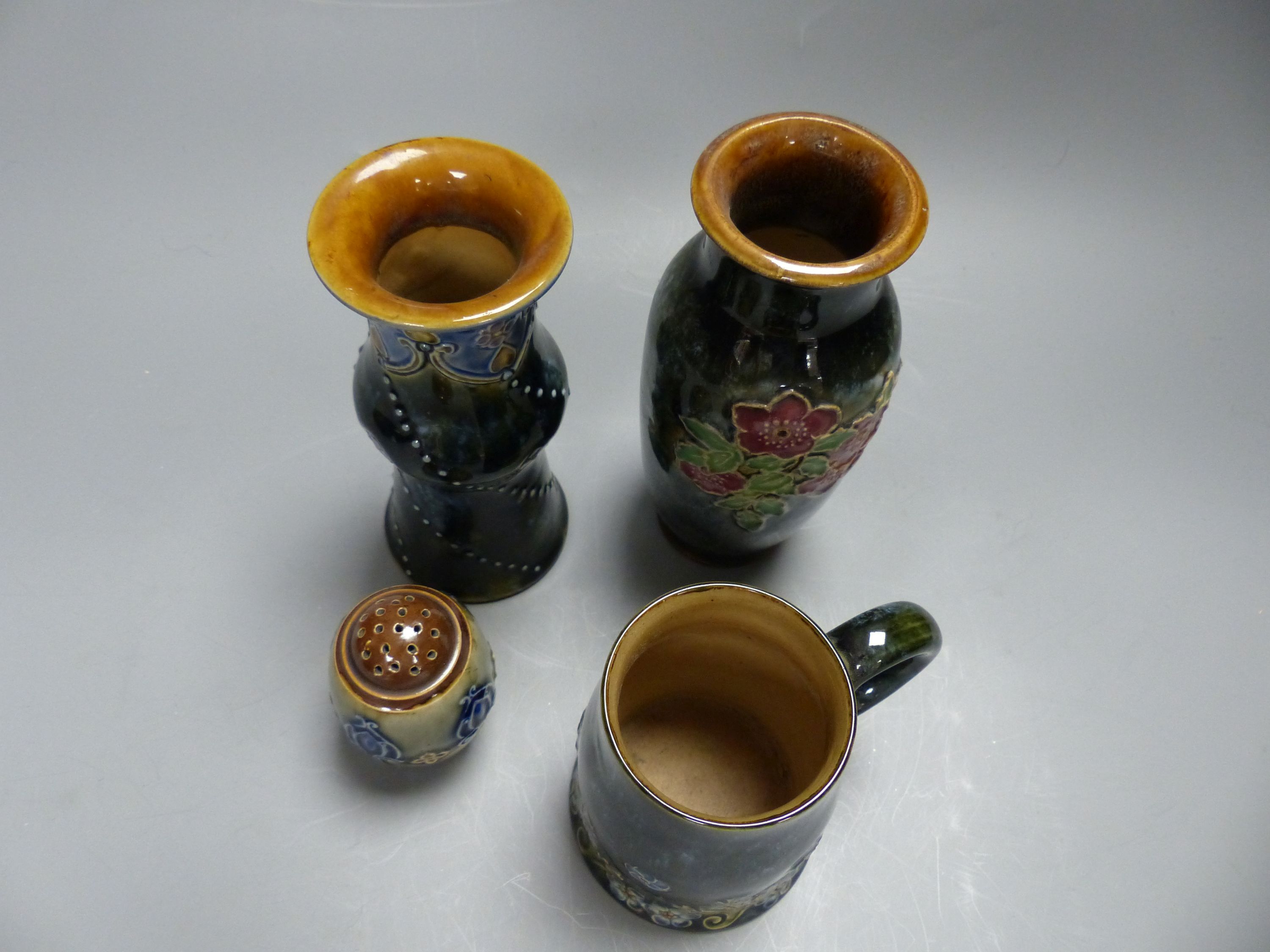 Four pieces of Royal Doulton stoneware including two vases, a mug and a pepperette, tallest 16cm